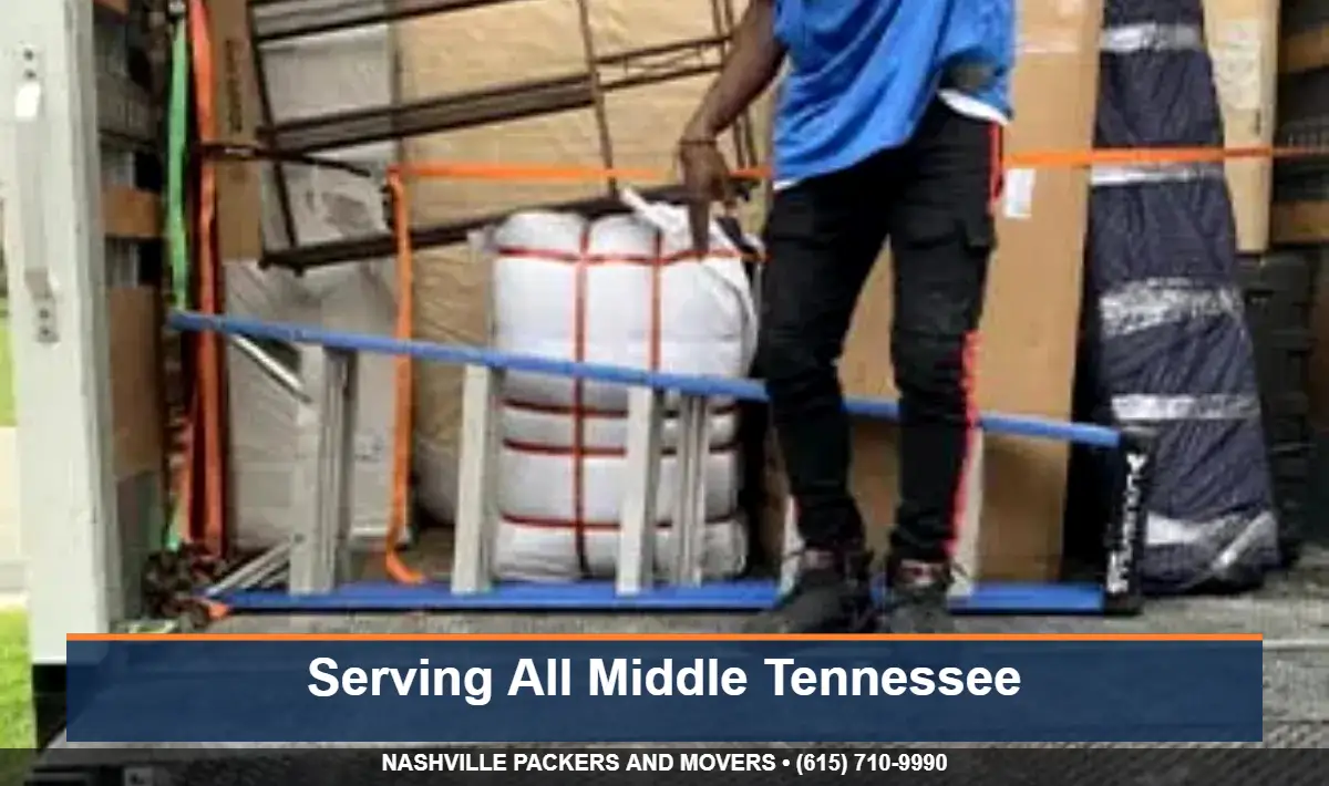 Mover securing a load with straps inside a Nashville Packers and Movers truck